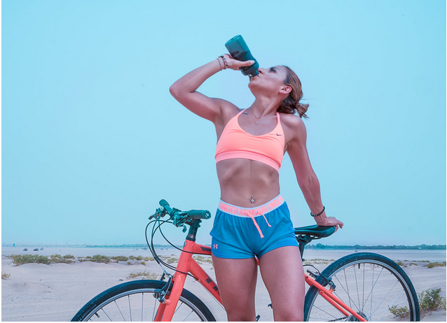 a lady drinking water when riding bike
